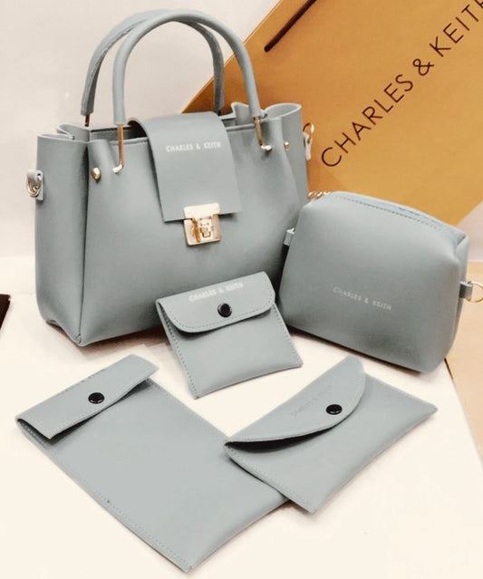 Set of gray handbags and wallets with 'Charles & Keith' branding on a beige background.